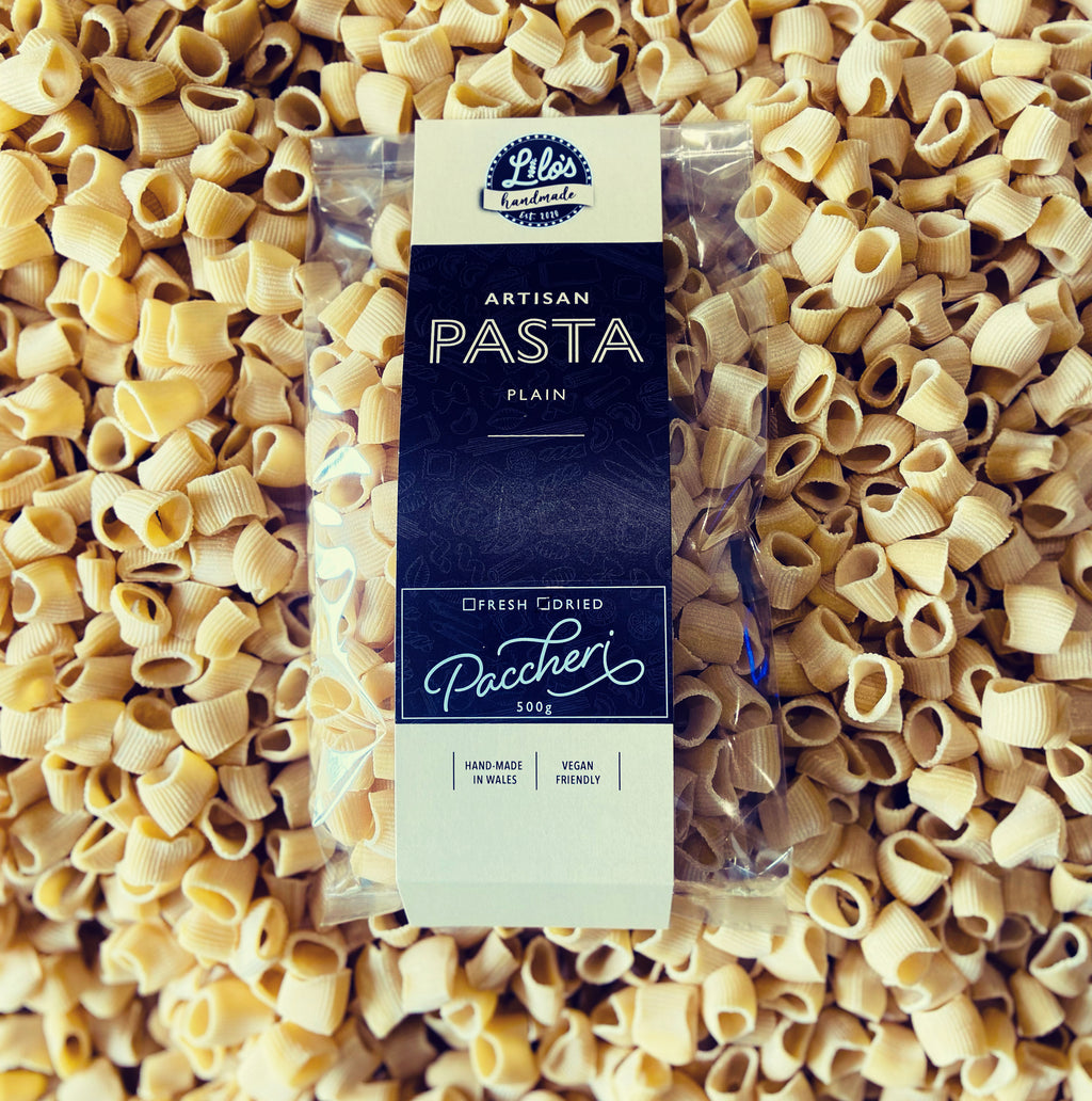 Paccheri pasta package surrounded by uncooked pasta