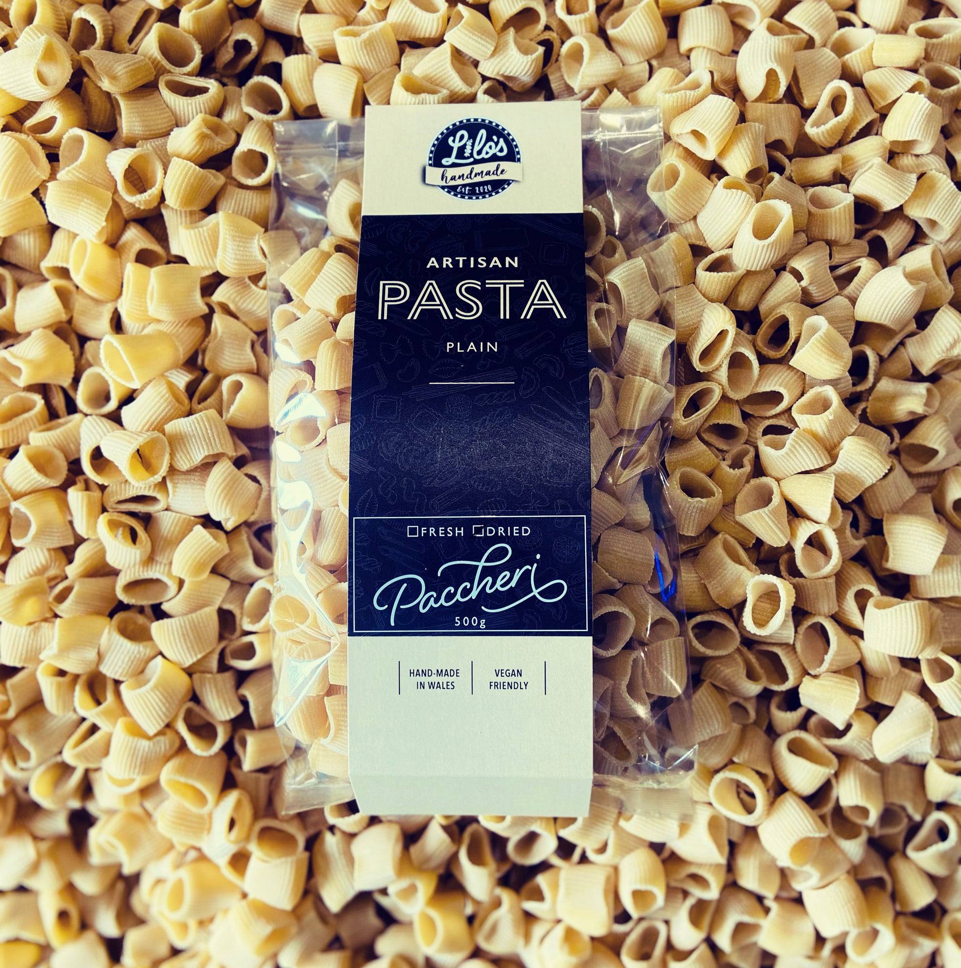 Paccheri pasta package surrounded by uncooked pasta