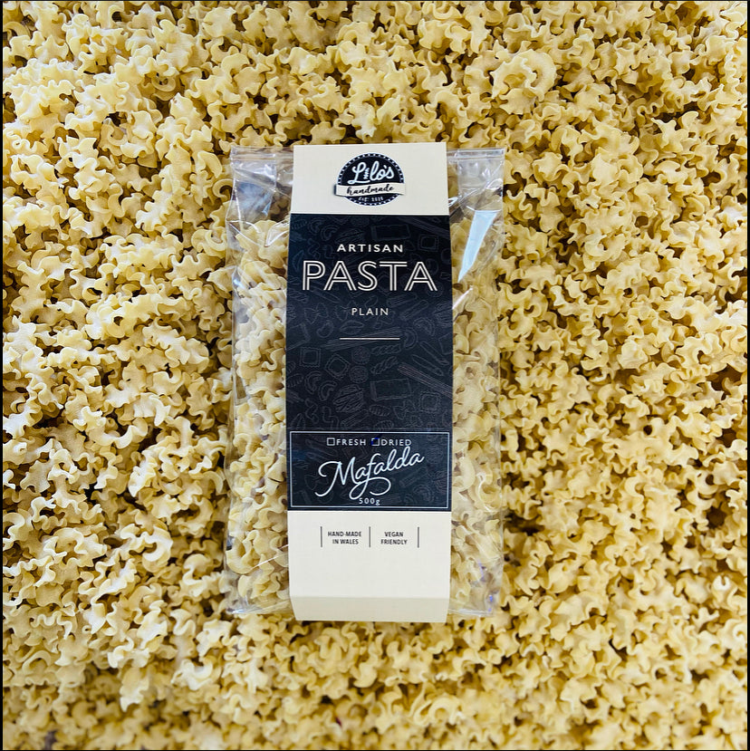 Packaged pasta with a label on a bed of uncooked pasta