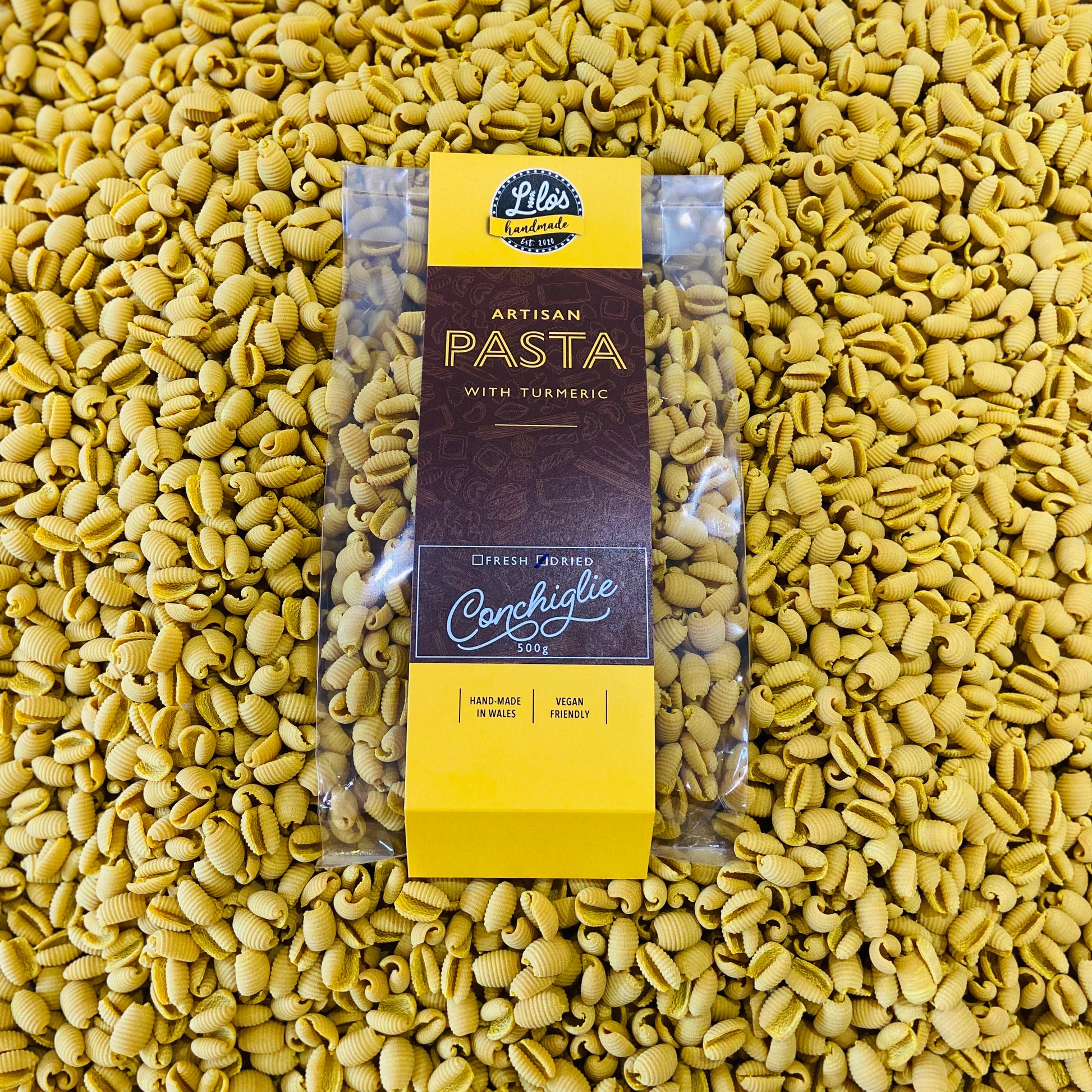 Packaged pasta with turmeric on a bed of green pasta